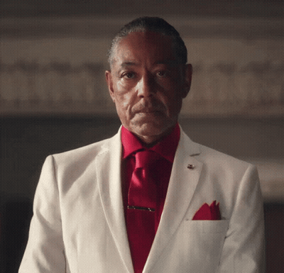 A Man Wearing A White Suit And Red Tie GIF