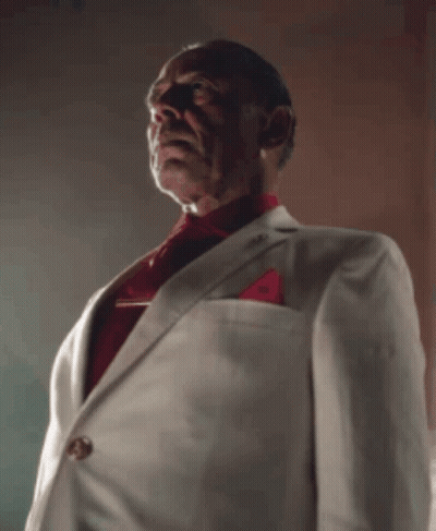A Man Wearing A White Suit And Red Tie GIF