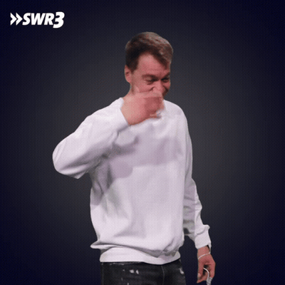 A Man Wearing A White Sweatshirt Is Making A Thumbs Up Sign With Swr3 In The Background GIF