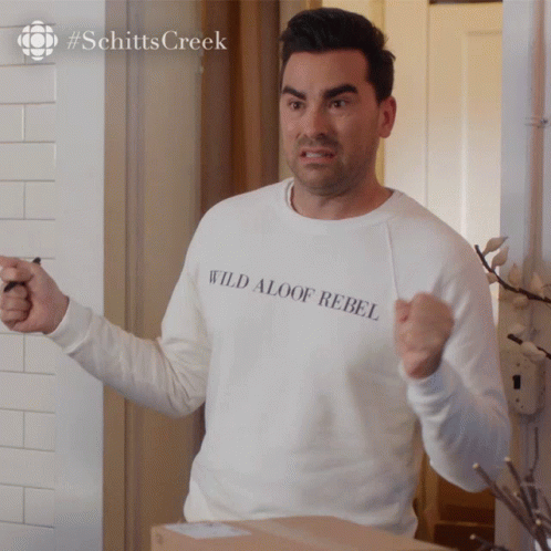 A Man Wearing A White Sweatshirt That Says Wild Aloof Rebel GIF