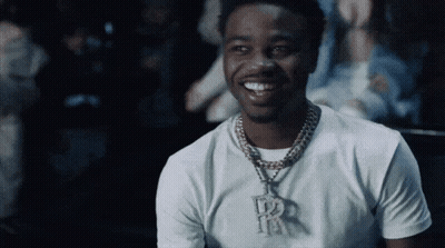 A Man Wearing A White T-Shirt And A Necklace With The Letter R On It GIF