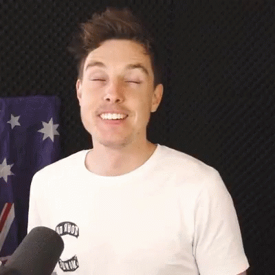 A Man Wearing A White T-Shirt Is Smiling With His Eyes Closed . GIF