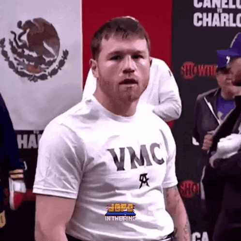 A Man Wearing A White T-Shirt That Says Vmc On It GIF