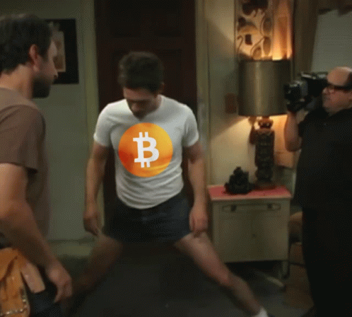 A Man Wearing A White T-Shirt With A Bitcoin Symbol On It GIF