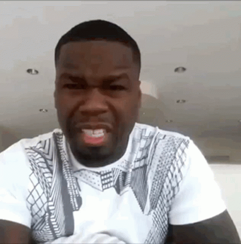 A Man Wearing A White T-Shirt With A Pattern On It Is Making A Funny Face GIF