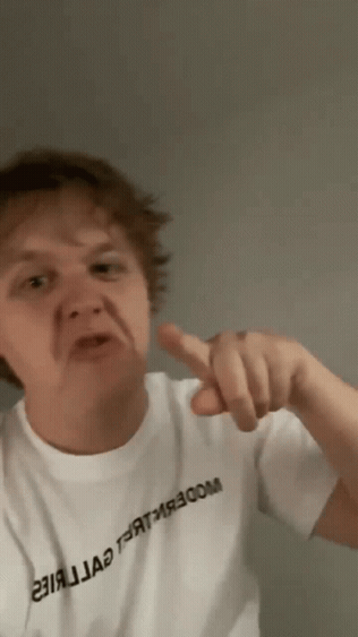 A Man Wearing A White T-Shirt With Russian Writing On It Is Pointing His Finger GIF