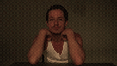 A Man Wearing A White Tank Top And A Gold Chain Around His Neck GIF