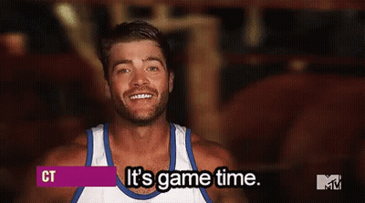 A Man Wearing A White Tank Top Is Smiling And Says It 'S Game Time . GIF