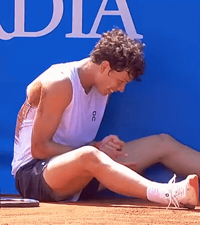 A Man Wearing A White Tank Top With The Word Oc On It Is Sitting On The Ground GIF