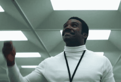 A Man Wearing A White Turtleneck And A Lanyard GIF