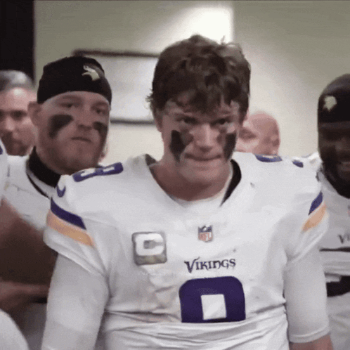 A Man Wearing A White Vikings Jersey With The Number 8 On It GIF