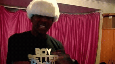 A Man Wearing A White Wig And A Black Shirt That Says Boy Better GIF