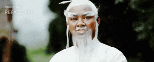 A Man Wearing A White Wig And Beard Is Standing In Front Of Trees . GIF