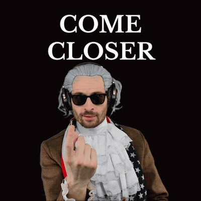 A Man Wearing A Wig And Headphones Has An American Flag Around His Waist GIF