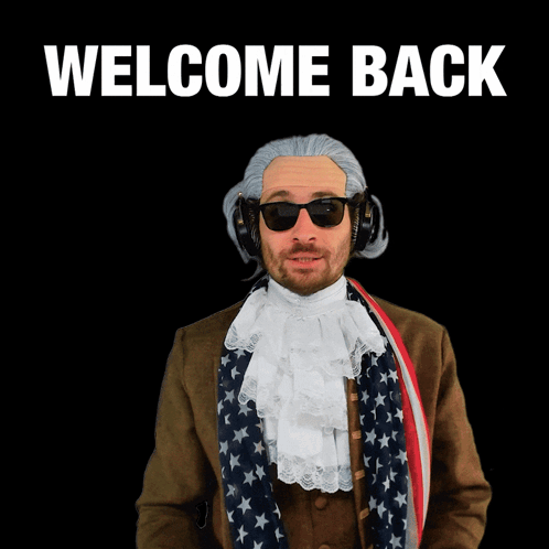 A Man Wearing A Wig And Sunglasses Holds Out His Hand In Front Of A Sign That Says Welcome Back GIF
