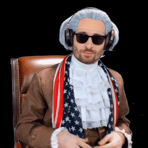 A Man Wearing A Wig And Sunglasses Is Wearing An American Flag Scarf Around His Neck GIF