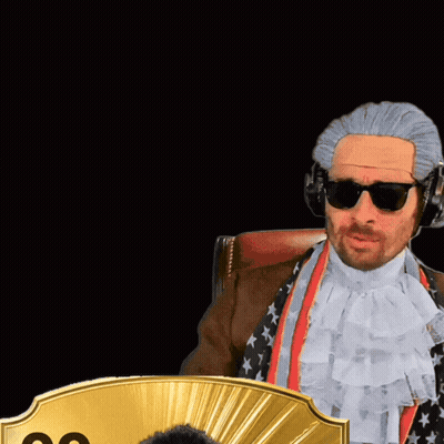 A Man Wearing A Wig And Sunglasses Stands Next To A Man Wearing A Suit And Tie With The Number 99 On It GIF