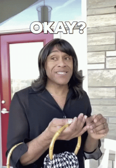 A Man Wearing A Wig Is Holding A Purse And The Word Okay Is Above Him GIF