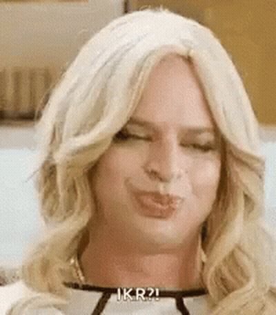 A Man Wearing A Wig Is Making A Funny Face . GIF