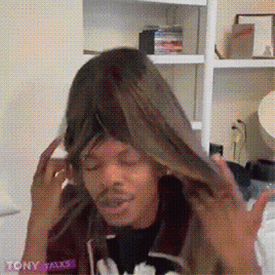 A Man Wearing A Wig With The Word Tony On The Bottom Right GIF