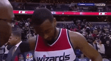 A Man Wearing A Wizards Jersey Is Talking To A Reporter GIF