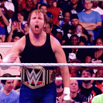 A Man Wearing A Wrestling Belt With The Letter W On It Stands In A Ring GIF