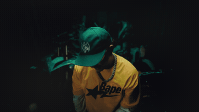 A Man Wearing A Yellow Bape Shirt And Sunglasses GIF