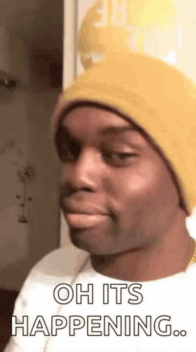 A Man Wearing A Yellow Beanie Is Making A Funny Face And Saying `` Oh It 'S Happening . '' GIF