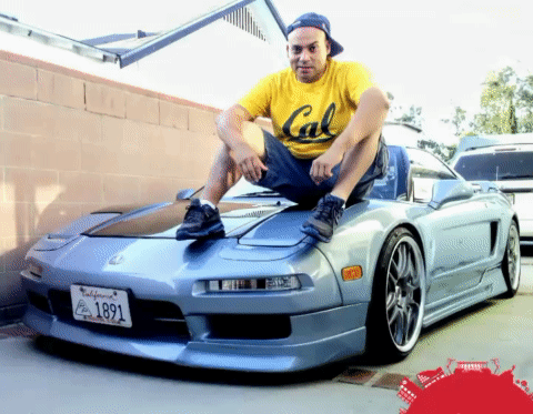 A Man Wearing A Yellow Cal Shirt Sits On Top Of A Car GIF