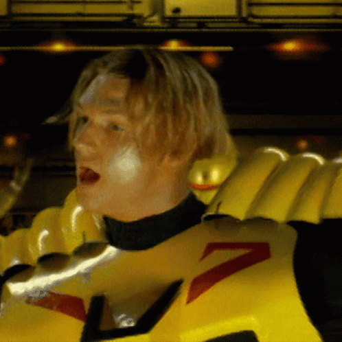 A Man Wearing A Yellow Costume With A Red Arrow On It GIF