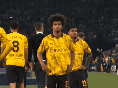 A Man Wearing A Yellow Evonk Jersey Stands In Front Of A Crowd GIF
