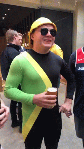 A Man Wearing A Yellow Hard Hat And Sunglasses Is Holding A Glass Of Beer GIF