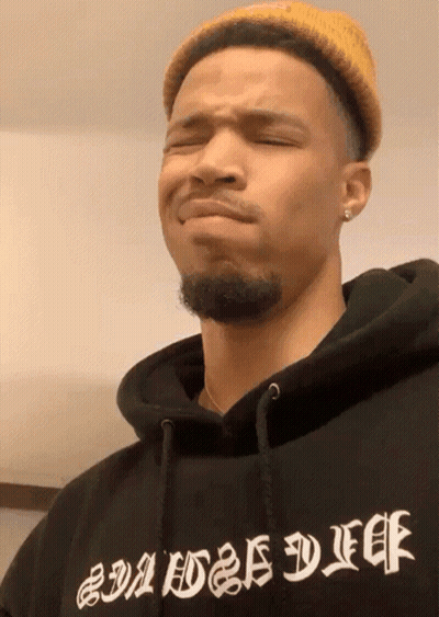A Man Wearing A Yellow Hat And A Black Hoodie That Says Baddest Duff GIF