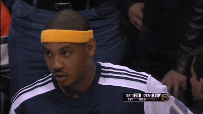 A Man Wearing A Yellow Headband Sits In The Stands During A Basketball Game GIF