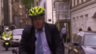 A Man Wearing A Yellow Helmet Is Riding A Bike GIF