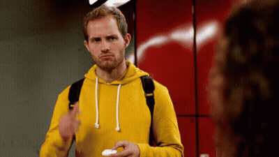 A Man Wearing A Yellow Hoodie Is Holding A White Object GIF