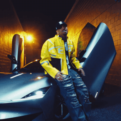 A Man Wearing A Yellow Jacket And A Black Hat Stands Next To A Car GIF