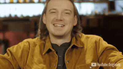 A Man Wearing A Yellow Jacket Is Smiling In Front Of A Youtube Originals Logo GIF