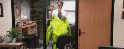 A Man Wearing A Yellow Jacket Is Standing In An Office GIF