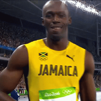 A Man Wearing A Yellow Jamaica Jersey Is Smiling GIF