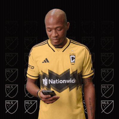 A Man Wearing A Yellow Jersey That Says Nationwide Looks At His Phone GIF