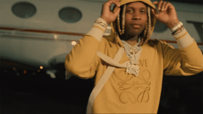A Man Wearing A Yellow Loewe Sweatshirt Is Adjusting His Hood GIF
