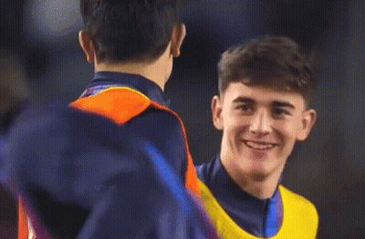 A Man Wearing A Yellow Nike Vest Is Smiling While Talking To Another Man GIF
