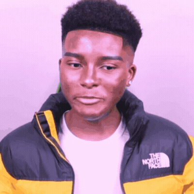 A Man Wearing A Yellow North Face Jacket Looks At The Camera GIF