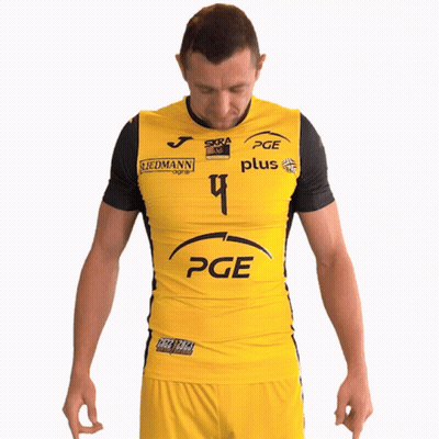 A Man Wearing A Yellow Pge Shirt Stands With His Hands On His Hips GIF