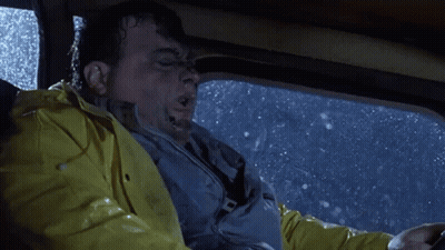 A Man Wearing A Yellow Raincoat Is Driving A Car In The Rain GIF