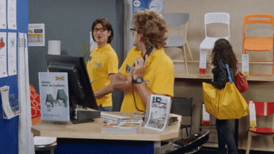 A Man Wearing A Yellow Shirt That Says Ikea On It Is Talking On A Phone GIF