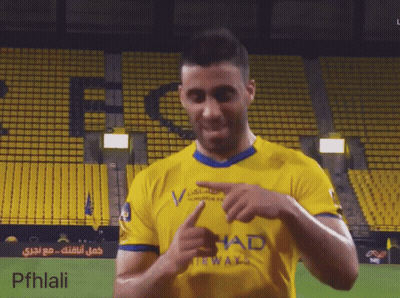 A Man Wearing A Yellow Shirt With Had On It GIF