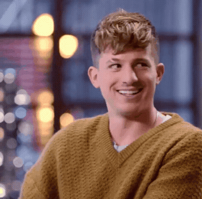 A Man Wearing A Yellow Sweater Is Smiling And Looking Up GIF