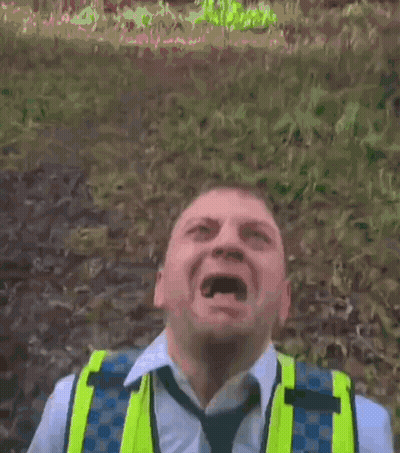 A Man Wearing A Yellow Vest And Tie Is Making A Face GIF